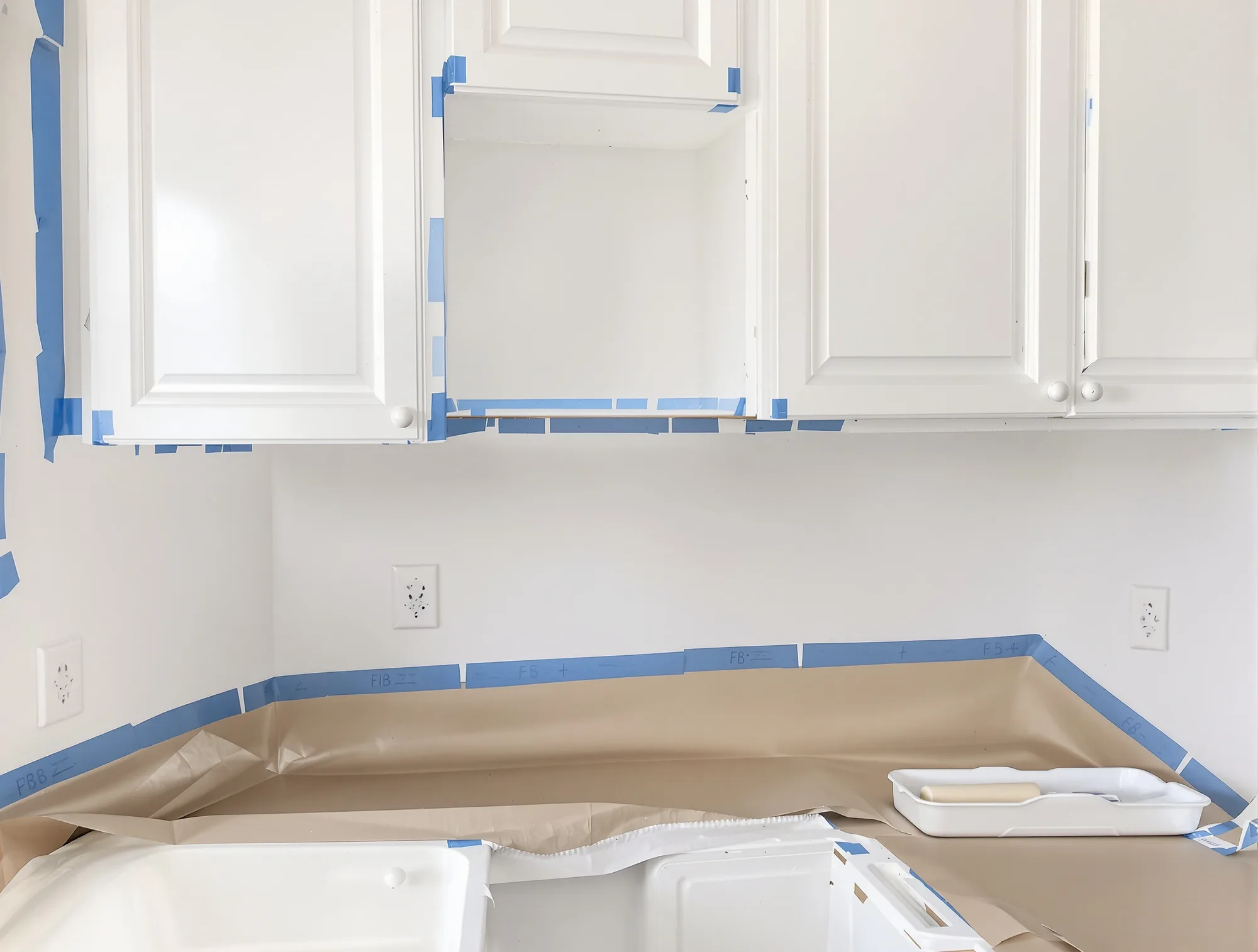 Cabinet frames freshly coated in bright white primer with crisp masked edges
