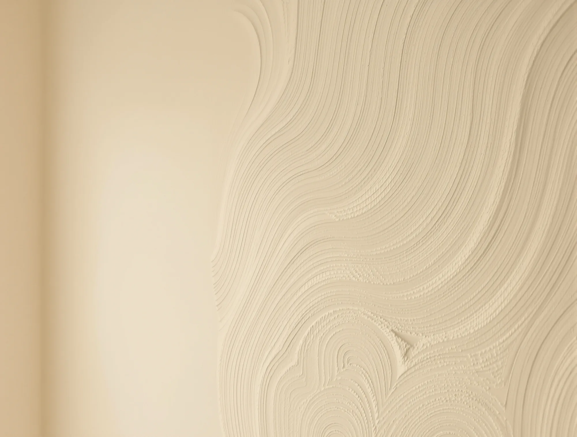 Close-up of hand troweled skip trowel plaster texture on a warm cream wall