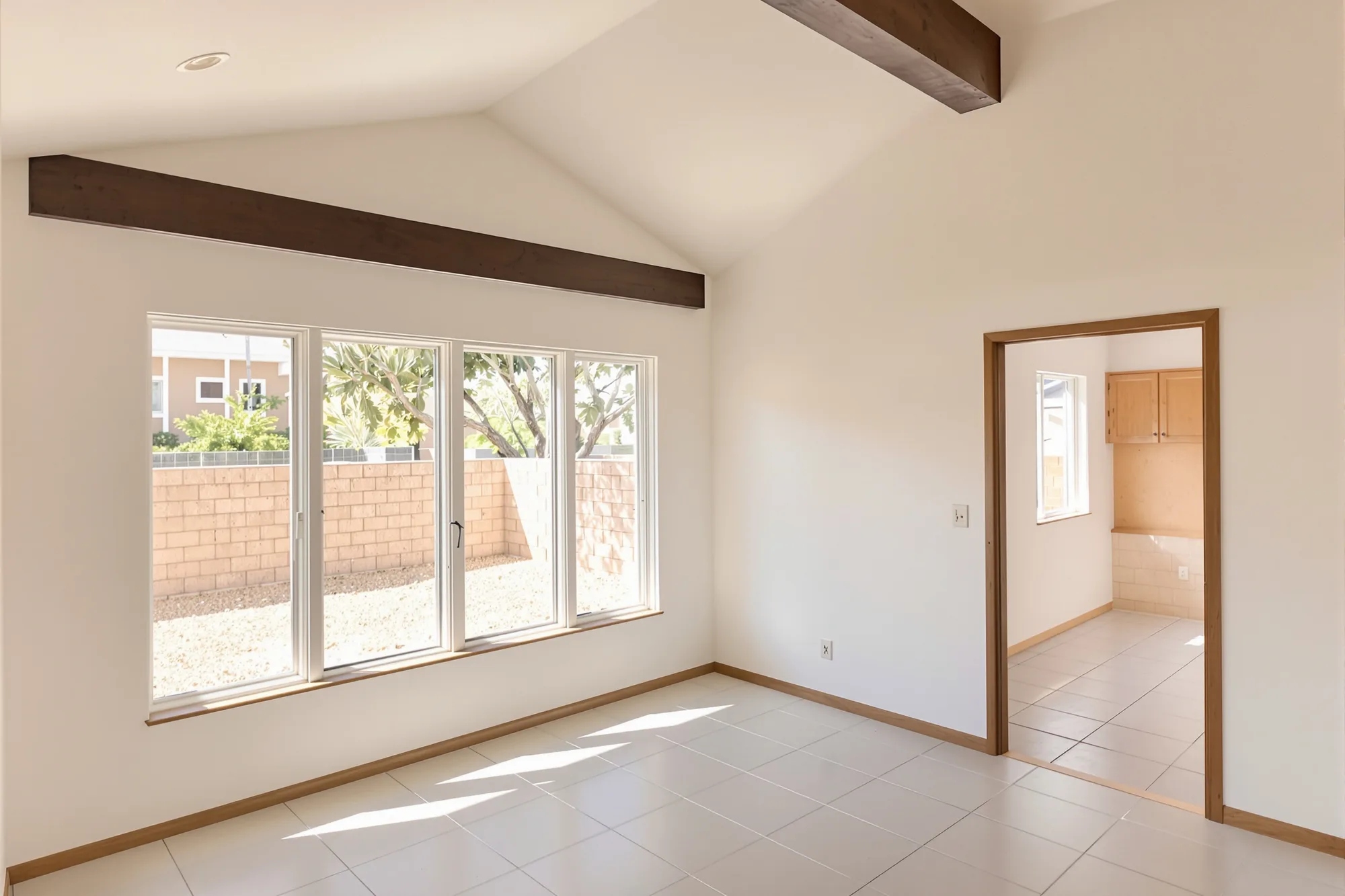 New room addition with warm white walls and a vaulted ceiling, opening into the older part of the home
