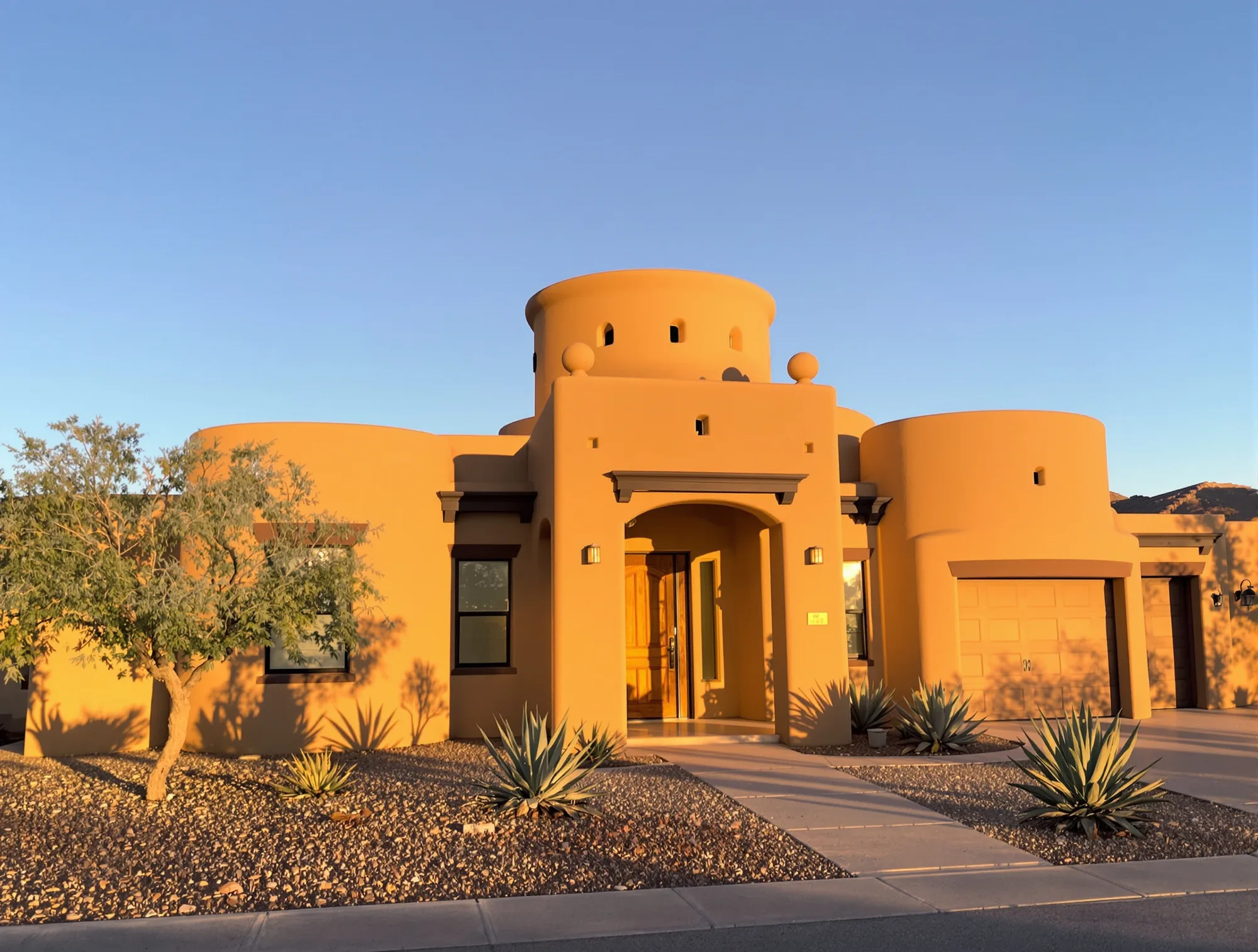 Freshly painted Pueblo Revival stucco home glowing at golden hour