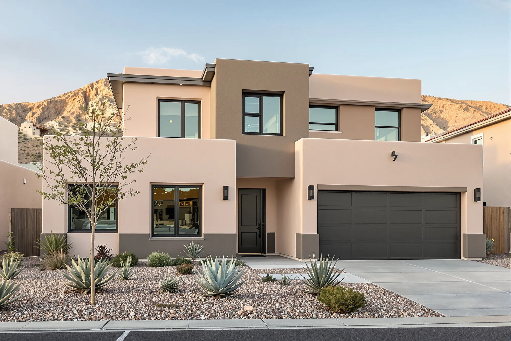 Two-story contemporary stucco home recolored in warm greige with charcoal brown accent walls